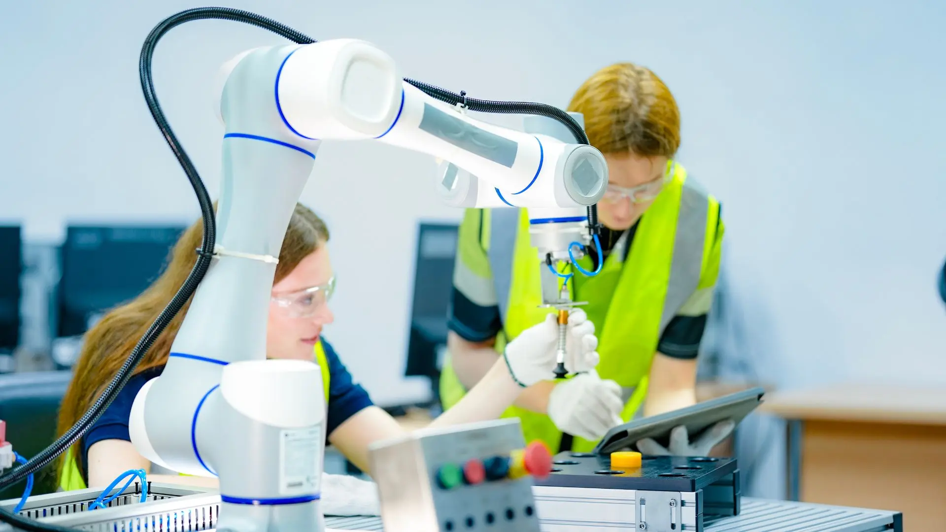 Ingénieurs travaillant avec un robot collaboratif dans une usine automatisée, illustrant la communication des innovations industrielles et la transformation digitale des entreprises.