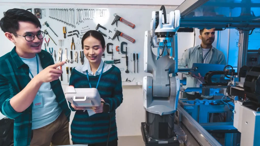 Ingénieurs devant un robot industriel en phase de test, illustrant la collaboration et la communication autour des innovations technologiques en industrie.