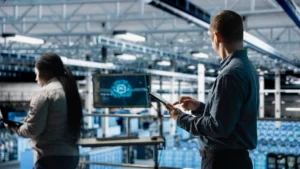 Ingénieurs devant une ligne automatisée utilisant des outils digitaux, illustrant la communication LinkedIn efficace pour les entreprises Industrie 4.0.